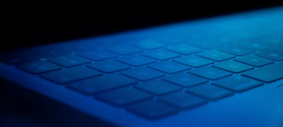 Laptop keyboard glowing in blue light